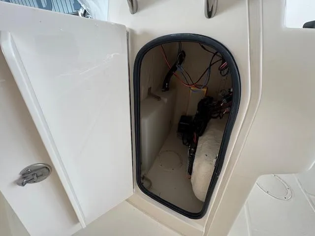 Slide: The Image of 2024 Grady-White Fisherman 180 storage compartment with wiring and equipment inside. - 14