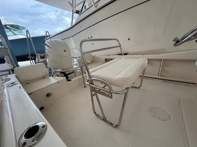 Slide: The Image of 2024 Grady-White Fisherman 180 boat interior with seating and motor, docked under cloudy sky. - 5