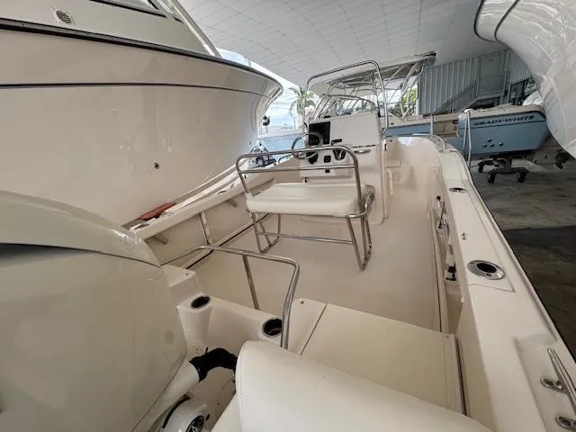 Slide: The Image of 2024 Grady-White Fisherman 180 boat interior, featuring seating and steering console in a showroom. - 7