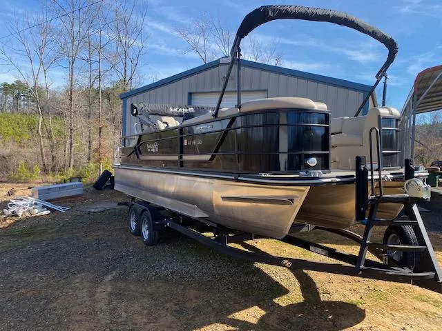Slide: The Image of 2023 SunCatcher Fusion 324SS pontoon boat on trailer, parked outdoors near a metal building. - 20