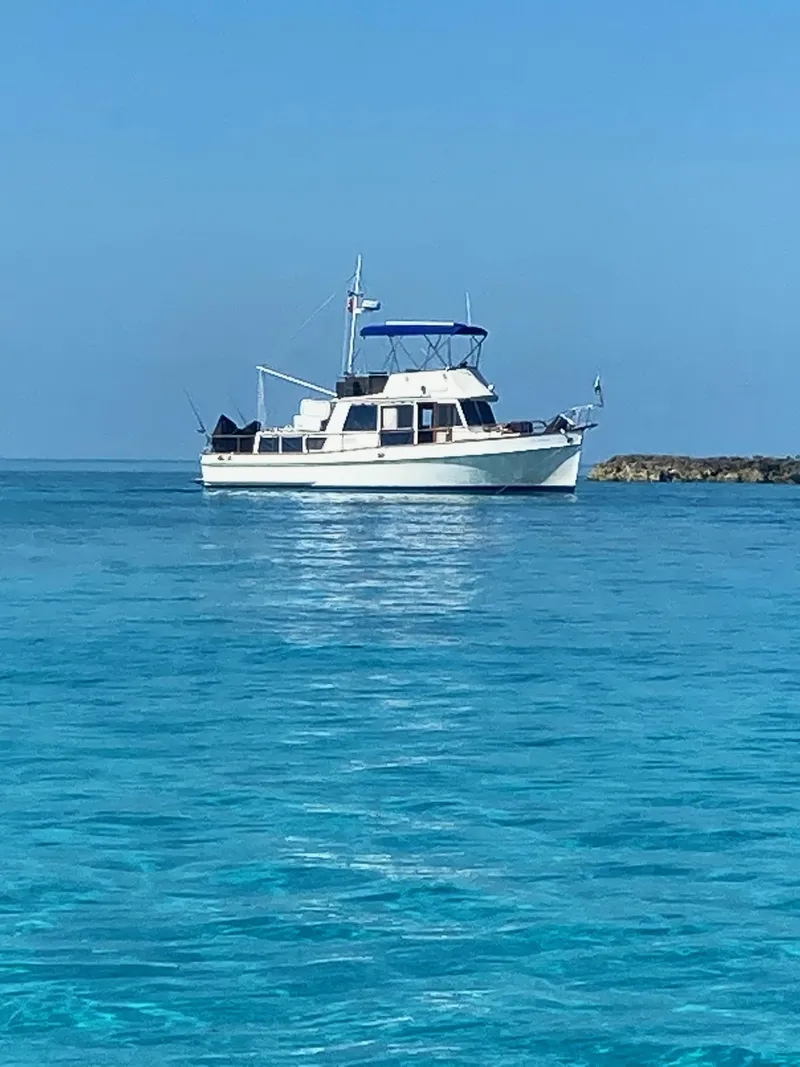 Slide: The Image of 1982 Grand Banks 36 Classic yacht on clear blue water, under a bright sky. - 0
