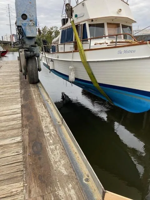 Slide: The Image of 1982 Grand Banks 36 Classic boat being lifted at a dock. - 10