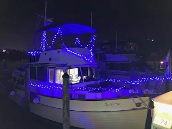 Slide: The Image of 1982 Grand Banks 36 Classic boat adorned with blue lights at night. - 11