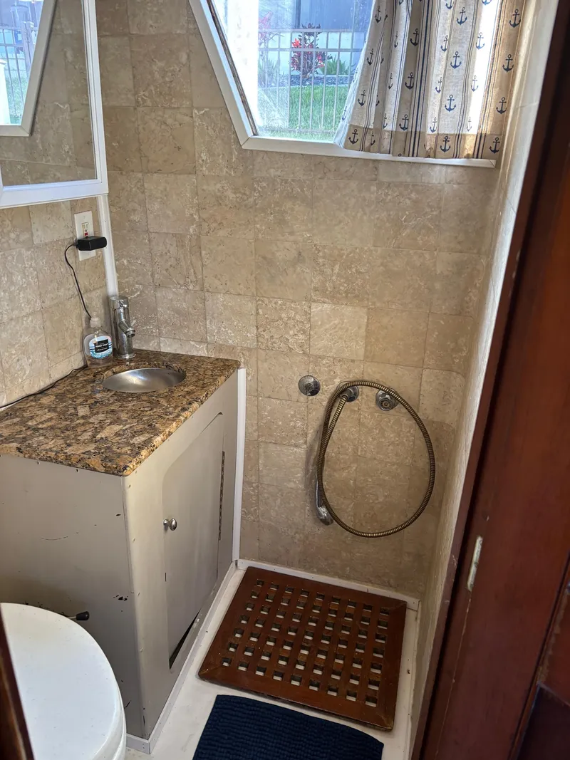 Slide: The Image of 1982 Grand Banks 36 Classic bathroom with sink, shower, and nautical-themed curtains. - 12