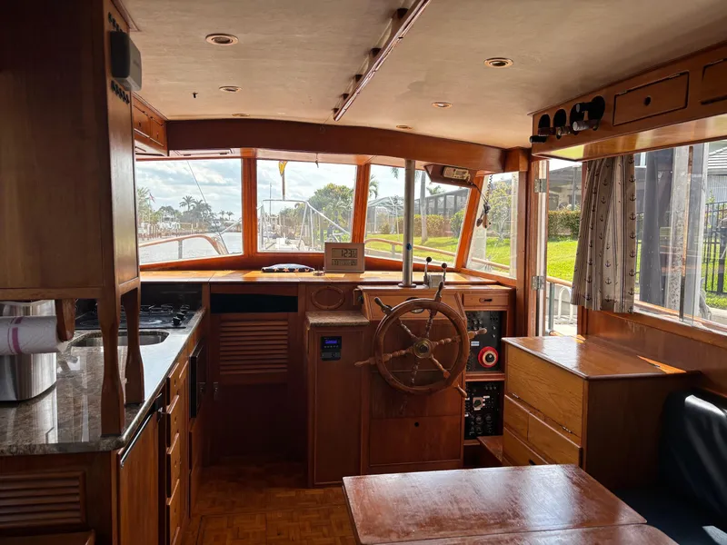 Slide: The Image of Interior of 1982 Grand Banks 36 Classic boat, featuring wooden helm and kitchen area. - 32