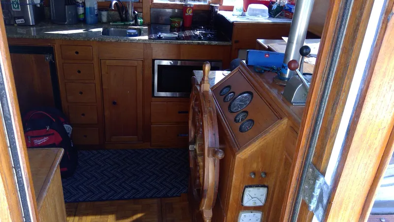 Slide: The Image of Interior of 1982 Grand Banks 36 Classic boat with wooden helm and kitchen area. - 5