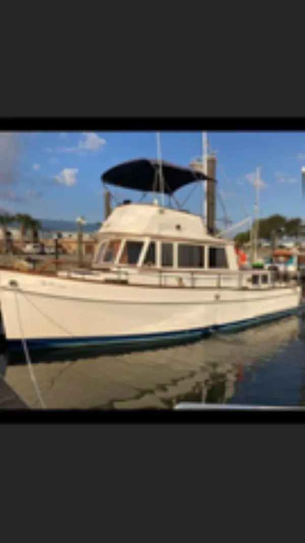 Slide: The Image of 1982 Grand Banks 36 Classic yacht docked at marina under clear sky. - 7