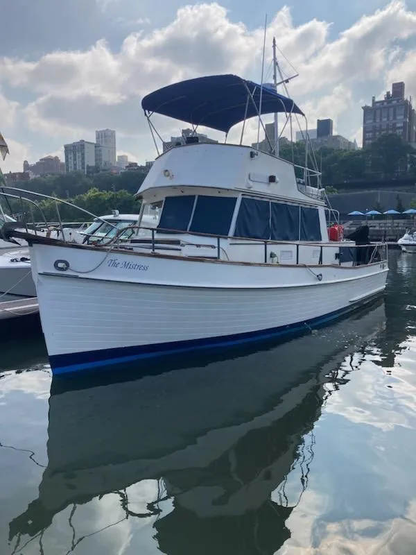Slide: The Image of 1982 Grand Banks 36 Classic yacht docked in a marina, city skyline in background. - 9