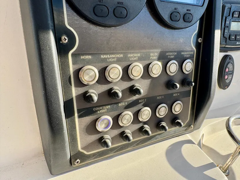 Slide: The Image of Control panel of a 2018 Sea Fox 226 Commander boat with various switches. - 15