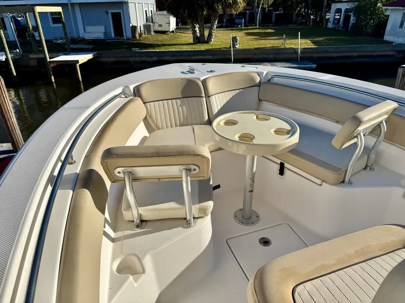 Slide: The Image of 2018 Sea Fox 226 Commander boat interior with seating and table, docked by waterfront homes. - 3