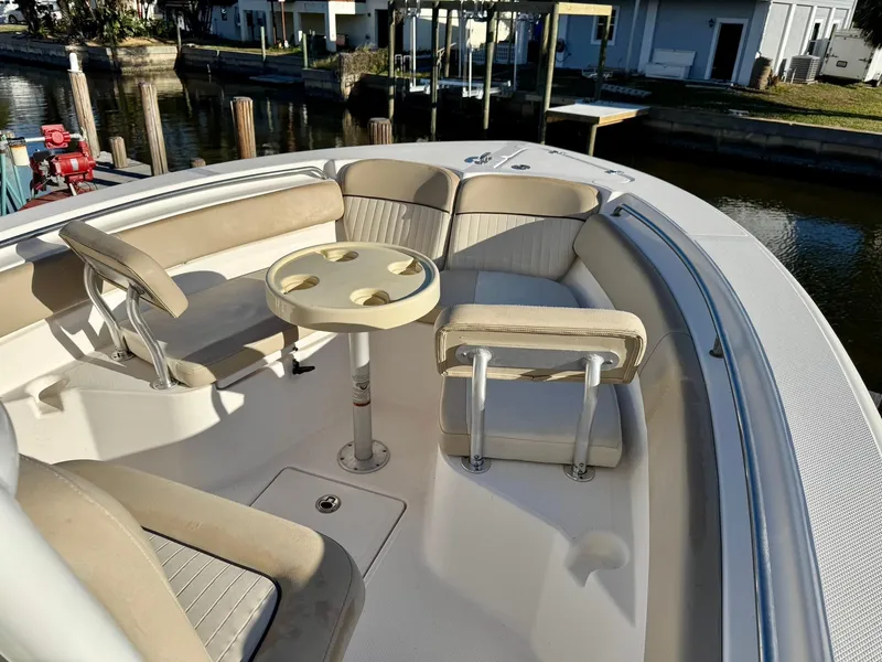 Slide: The Image of 2018 Sea Fox 226 Commander boat interior with seating and table, docked by waterfront homes. - 4