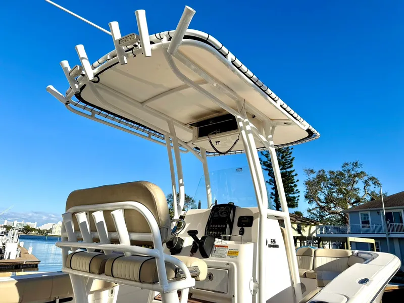 Slide: The Image of 2018 Sea Fox 226 Commander boat with T-top and seating, docked under clear blue sky. - 5