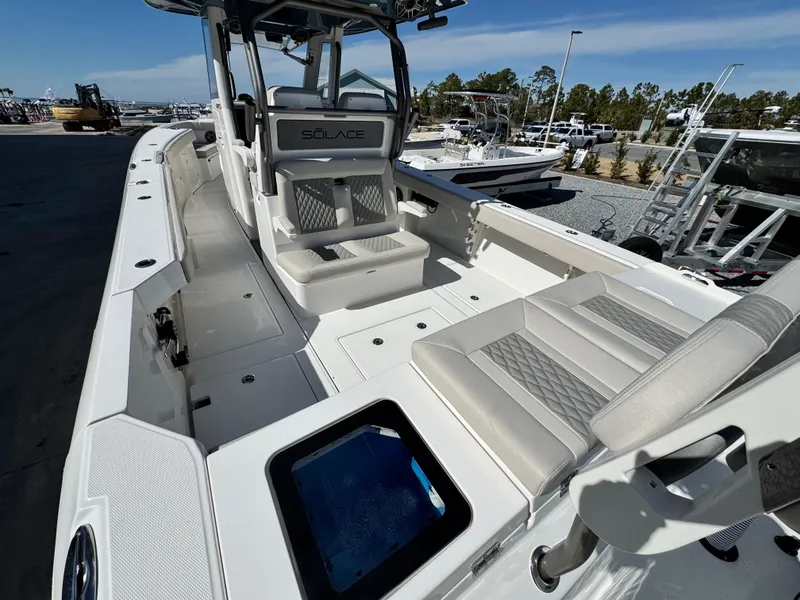 Slide: The Image of 2025 Solace 32 CS boat interior with seating and storage, docked at a marina. - 11
