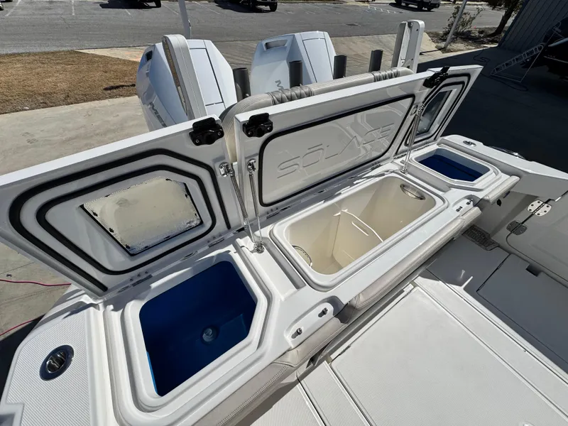 Slide: The Image of 2025 Solace 32 CS boat with open storage compartments and visible outboard engines. - 14