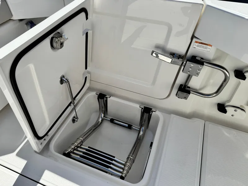 Slide: The Image of 2025 Solace 32 CS boat ladder compartment with open hatch and stainless steel ladder. - 18