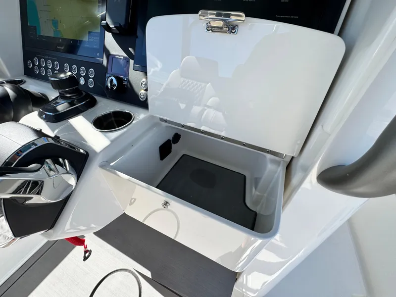 Slide: The Image of 2025 Solace 32 CS boat console with open storage compartment and control panel. - 27