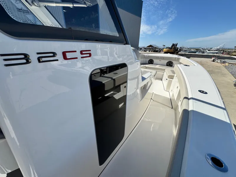 Slide: The Image of 2025 Solace 32 CS boat, sleek design, docked under clear blue sky. - 29