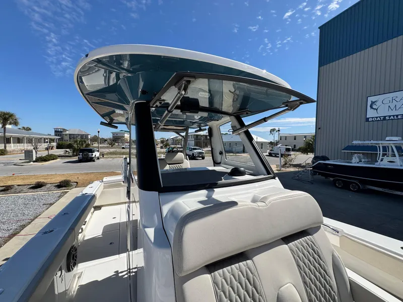 Slide: The Image of 2025 Solace 32 CS boat with sleek design, docked at marina under clear blue sky. - 30