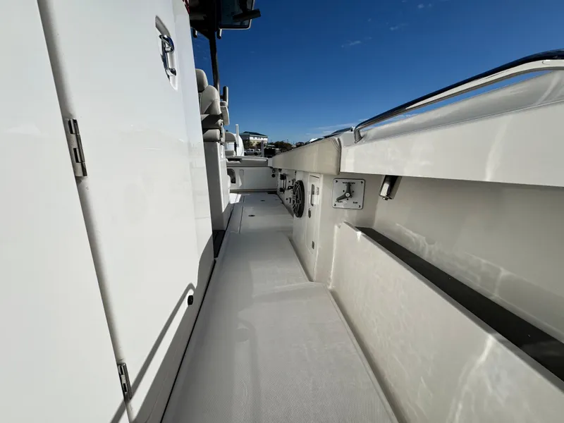 Slide: The Image of 2025 Solace 32 CS boat deck with sleek white design under clear blue sky. - 35