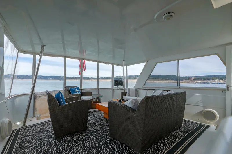 Slide: The Image of 1998 Hatteras 52 Sport Deck Motor Yacht interior with wicker seating and ocean view. - 14