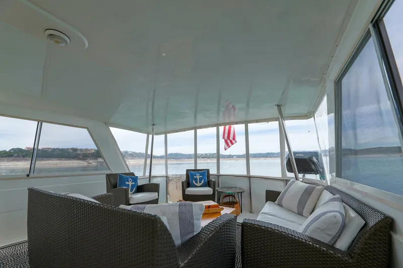 Slide: The Image of 1998 Hatteras 52 Sport Deck Motor Yacht interior with wicker seating and scenic water view. - 15