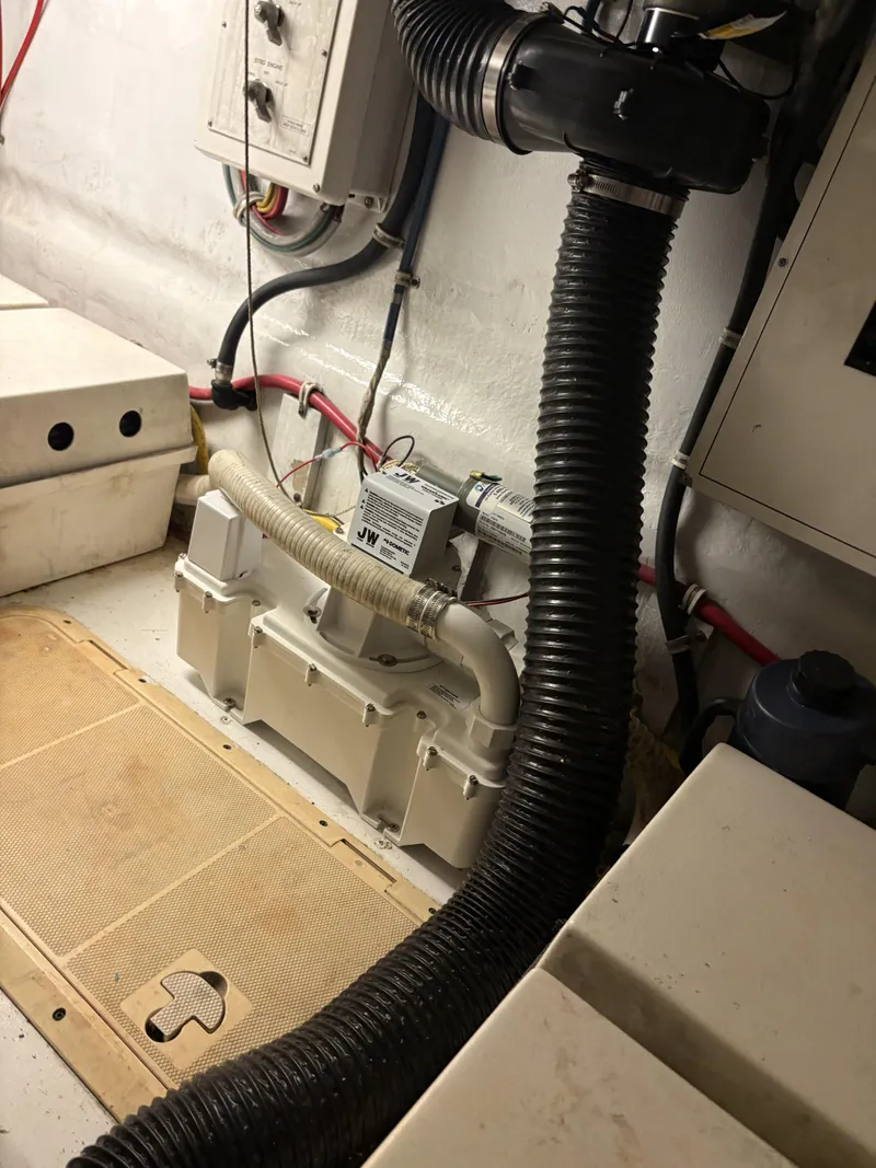 Slide: The Image of Engine room of 1998 Hatteras 52 Sport Deck Motor Yacht with visible hoses and equipment. - 26