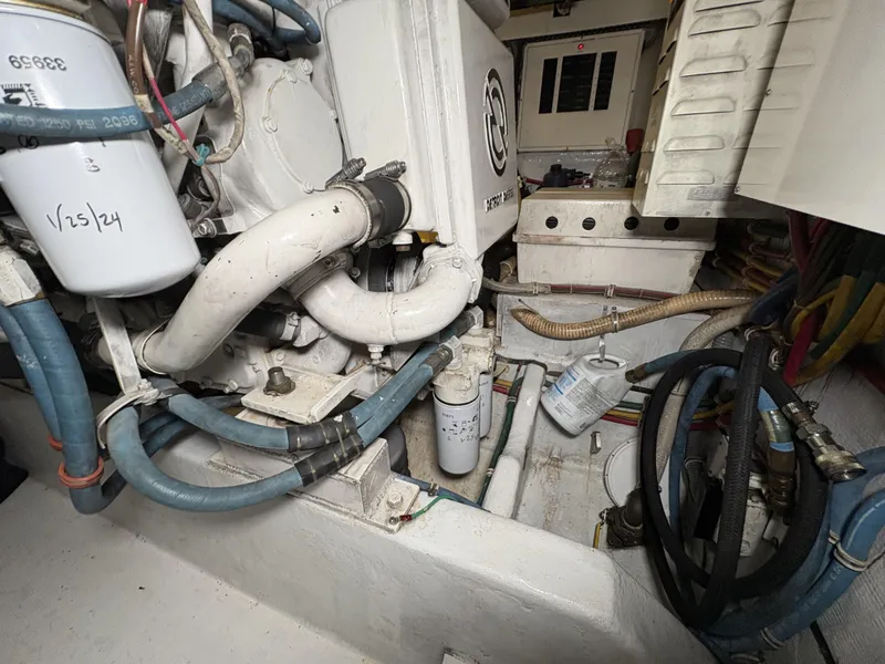 Slide: The Image of Engine room of 1998 Hatteras 52 Sport Deck Motor Yacht with visible hoses and components. - 29