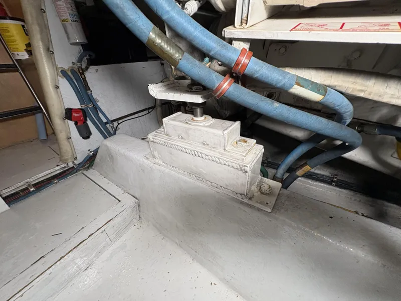 Slide: The Image of Engine room of 1998 Hatteras 52 Sport Deck Motor Yacht with visible hoses and machinery. - 33