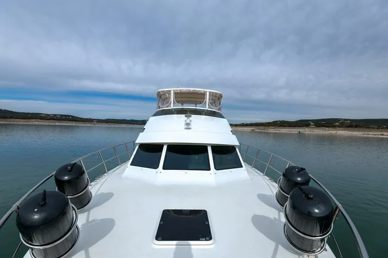 Slide: The Image of 1998 Hatteras 52 Sport Deck Motor Yacht on calm water under cloudy sky. - 41