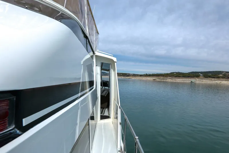 Slide: The Image of 1998 Hatteras 52 Sport Deck Motor Yacht on calm water, side view. - 42