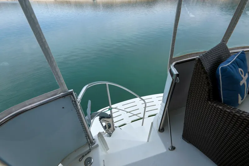 Slide: The Image of 1998 Hatteras 52 Sport Deck Motor Yacht stern view with wicker seating and water backdrop. - 46