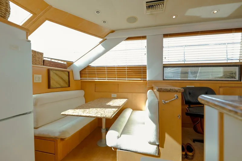 Slide: The Image of Interior of 1998 Hatteras 52 Sport Deck Motor Yacht with dining area and seating. - 8