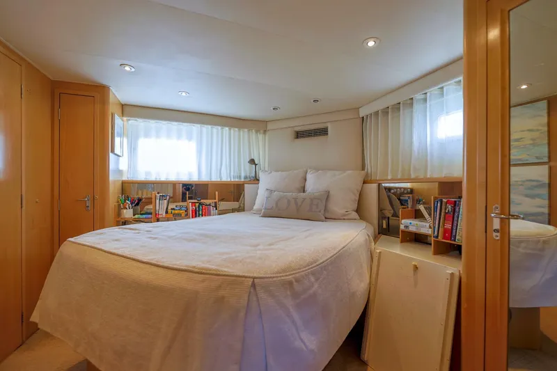 Slide: The Image of 1998 Hatteras 52 Sport Deck Motor Yacht bedroom with cozy bed and wooden cabinetry. - 9