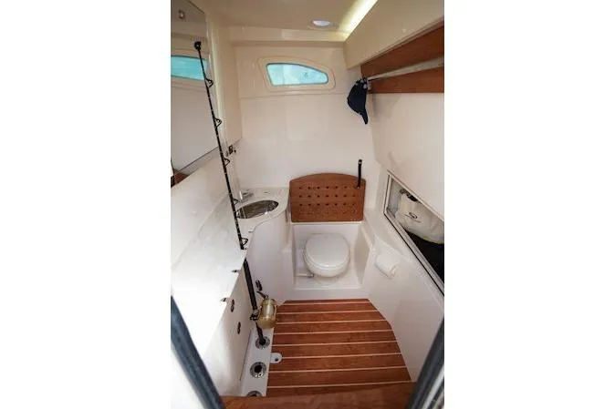 Slide: The Image of 2026 Grady-White Canyon 326 boat interior with compact bathroom, featuring toilet and sink. - 7