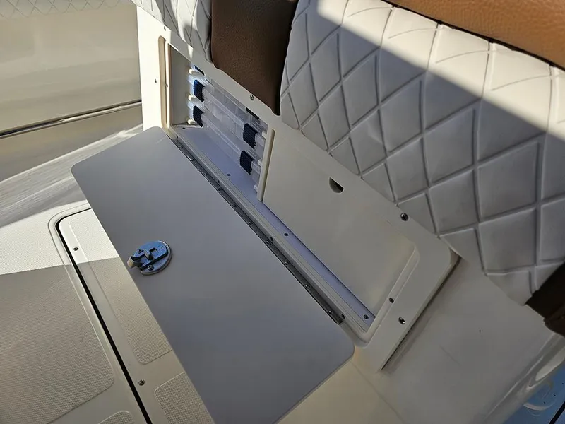 Slide: The Image of 2025 Pioneer 222 Sportfish boat storage compartment with quilted seating detail. - 14