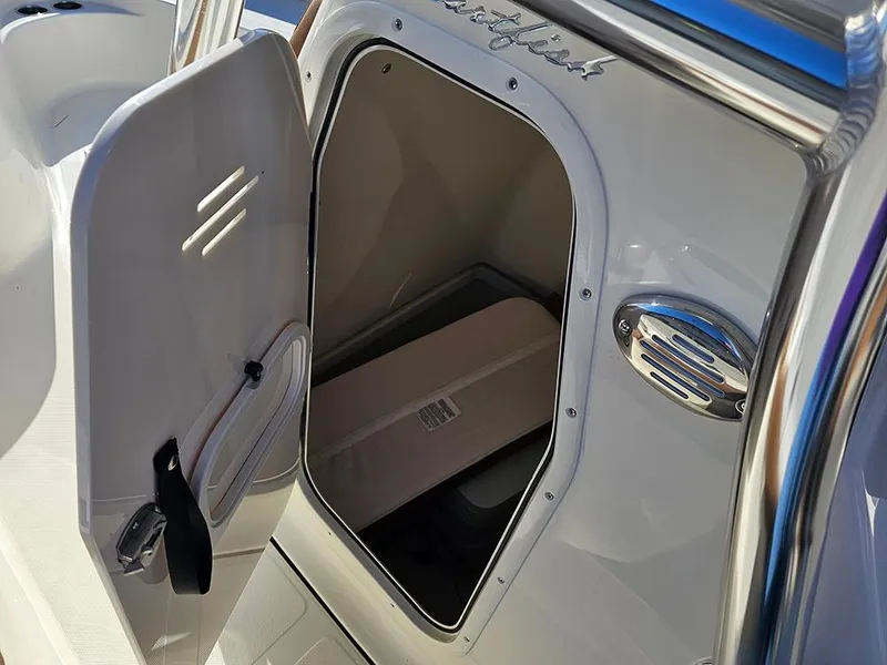 Slide: The Image of 2025 Pioneer 222 Sportfish boat storage compartment with open door, showcasing interior space. - 20