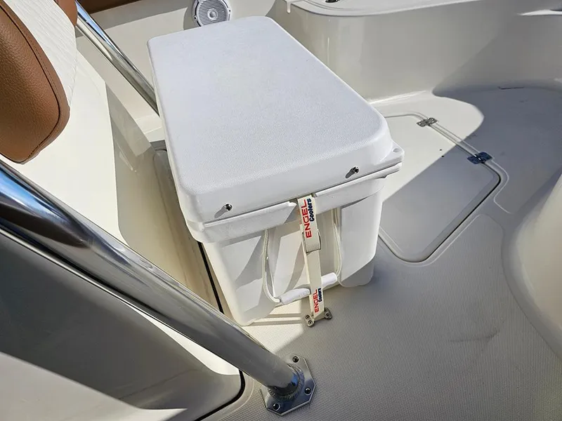 Slide: The Image of 2025 Pioneer 222 Sportfish boat interior with cushioned seating and storage compartment. - 25