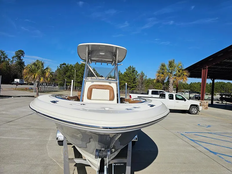 Slide: The Image of 2025 Pioneer 222 Sportfish boat on trailer, parked outdoors under clear blue sky. - 4