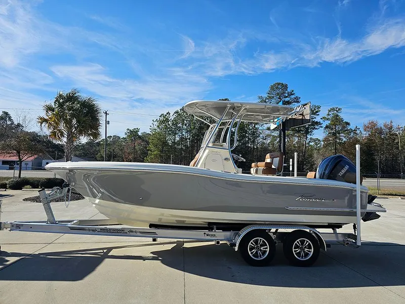 Slide: The Image of 2025 Pioneer 222 Sportfish boat on trailer, parked outdoors under clear blue sky. - 6