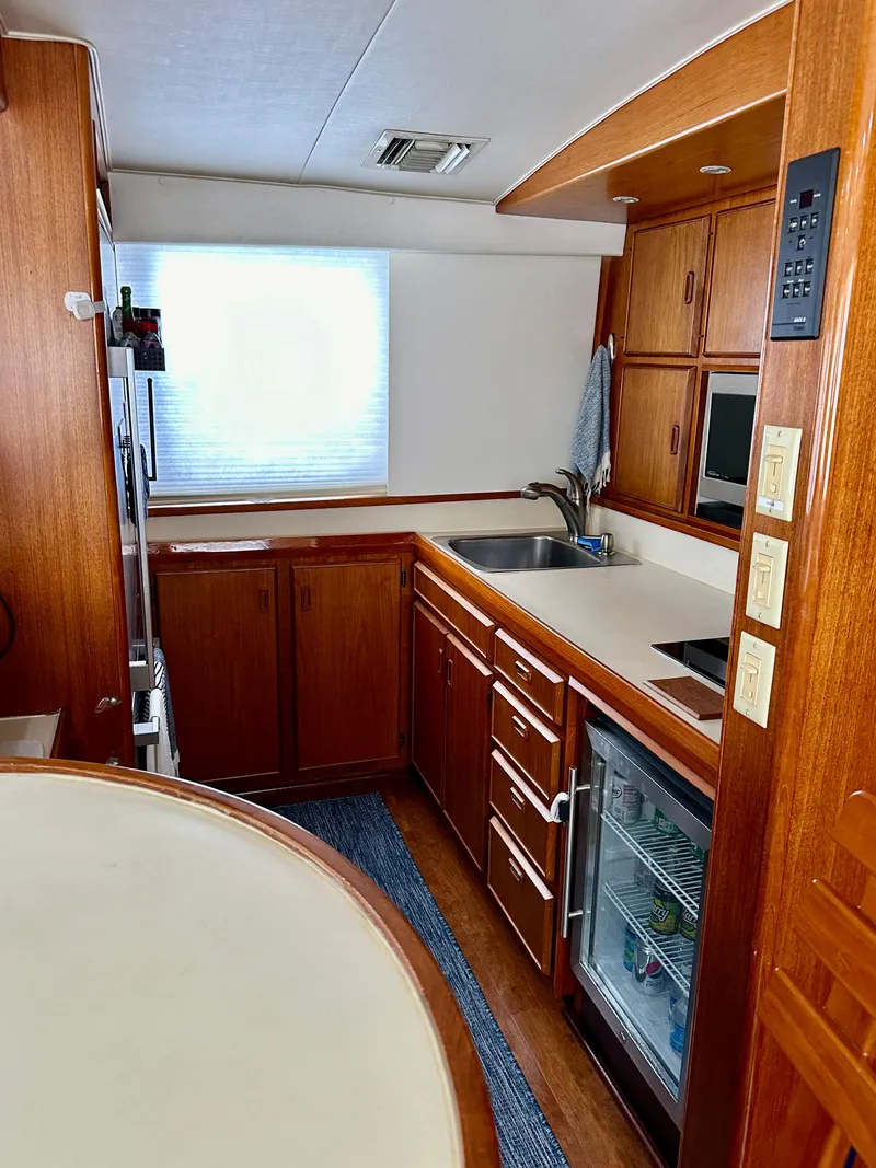 Slide: The Image of 1982 Bertram 54 Convertible yacht kitchen with wooden cabinetry and modern appliances. - 19