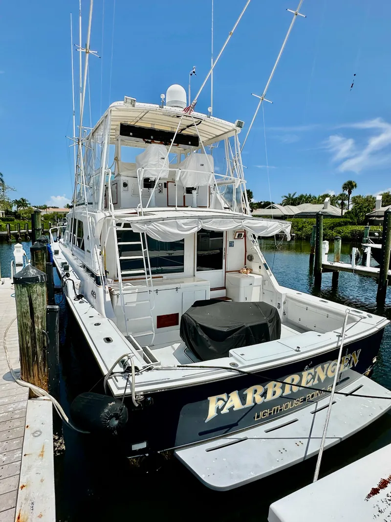 Slide: The Image of 1982 Bertram 54 Convertible yacht docked, rear view, sunny day, marina setting. - 2