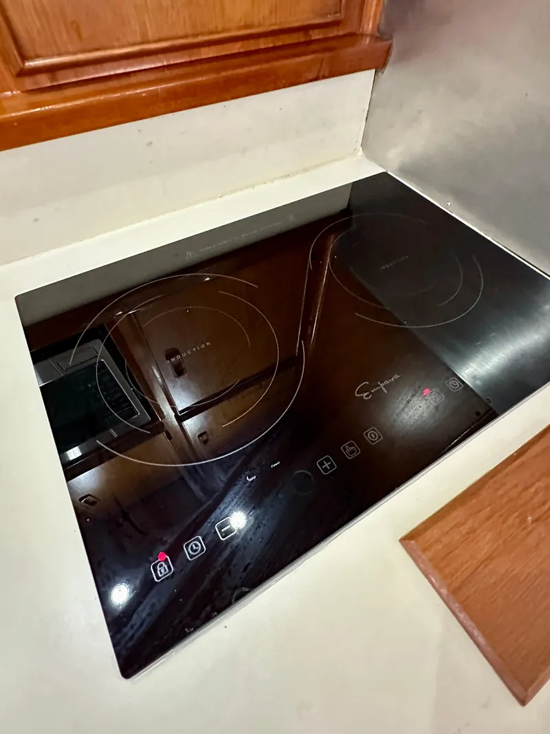 Slide: The Image of Modern induction cooktop in a 1982 Bertram 54 Convertible yacht kitchen. - 25