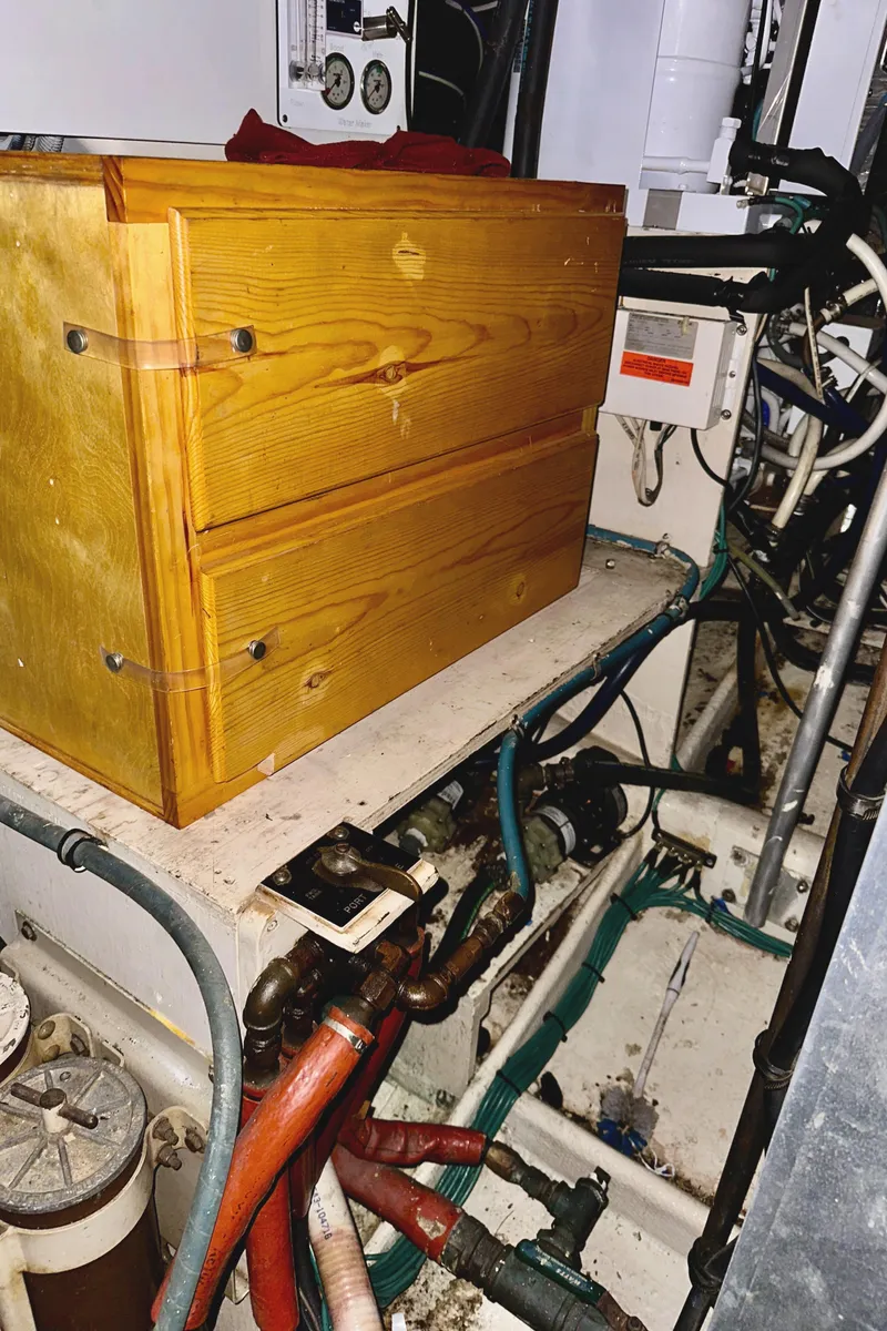 Slide: The Image of Engine room of 1982 Bertram 54 Convertible with wooden box and visible wiring. - 46