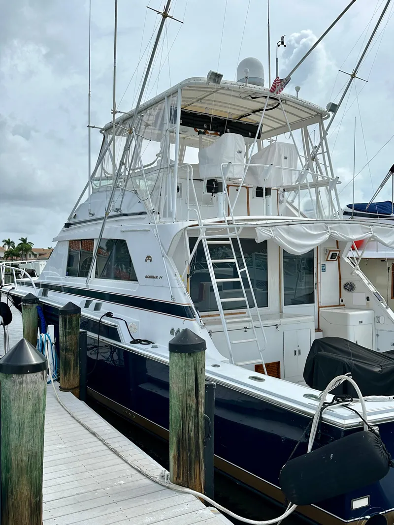 Slide: The Image of 1982 Bertram 54 Convertible yacht docked at a marina, showcasing its classic design. - 5