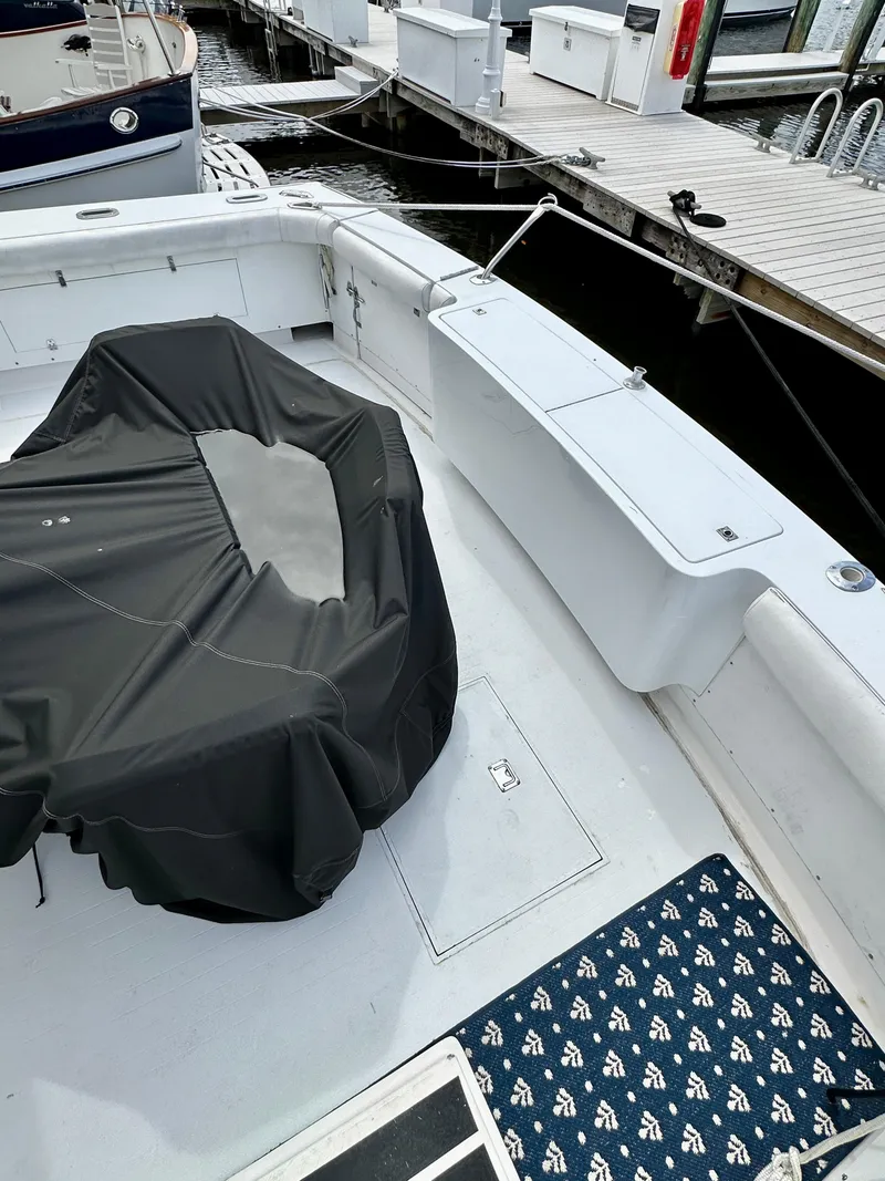 Slide: The Image of 1982 Bertram 54 Convertible boat deck with covered seating, docked at marina. - 7