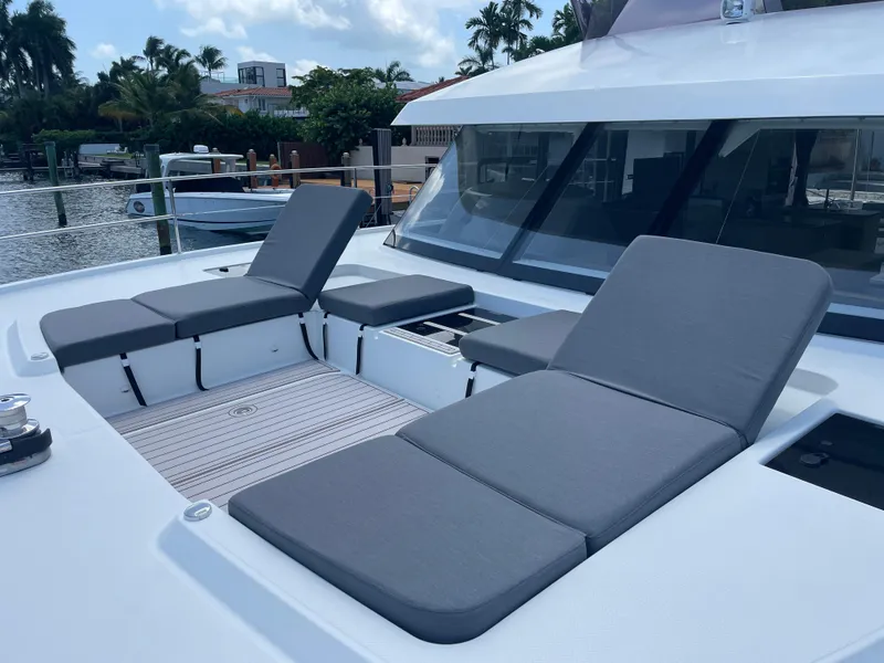 Slide: The Image of Luxury sun loungers on 2020 Fountaine Pajot MY 44 yacht deck, docked by waterfront homes. - 17