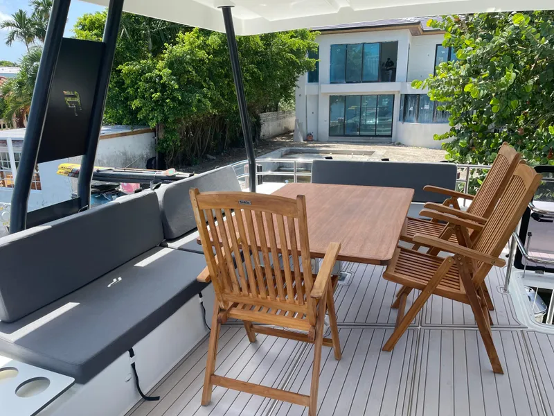 Slide: The Image of Fountaine Pajot MY 44 yacht deck with wooden chairs and table, 2020 model. - 24