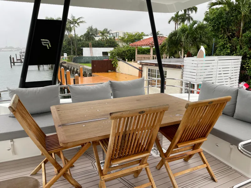 Slide: The Image of Outdoor seating area on a 2020 Fountaine Pajot MY 44 yacht, featuring wooden table and chairs. - 26