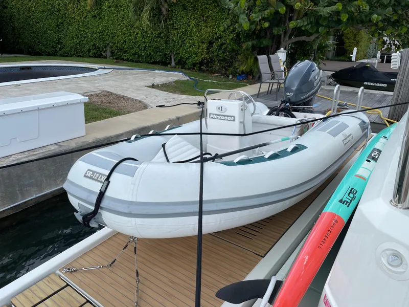 Slide: The Image of Inflatable boat docked beside a Fountaine Pajot MY 44, 2020 model, with lush greenery background. - 7