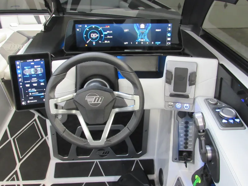 Slide: The Image of 2025 Malibu M230 boat dashboard with advanced digital displays and modern steering wheel design. - 11